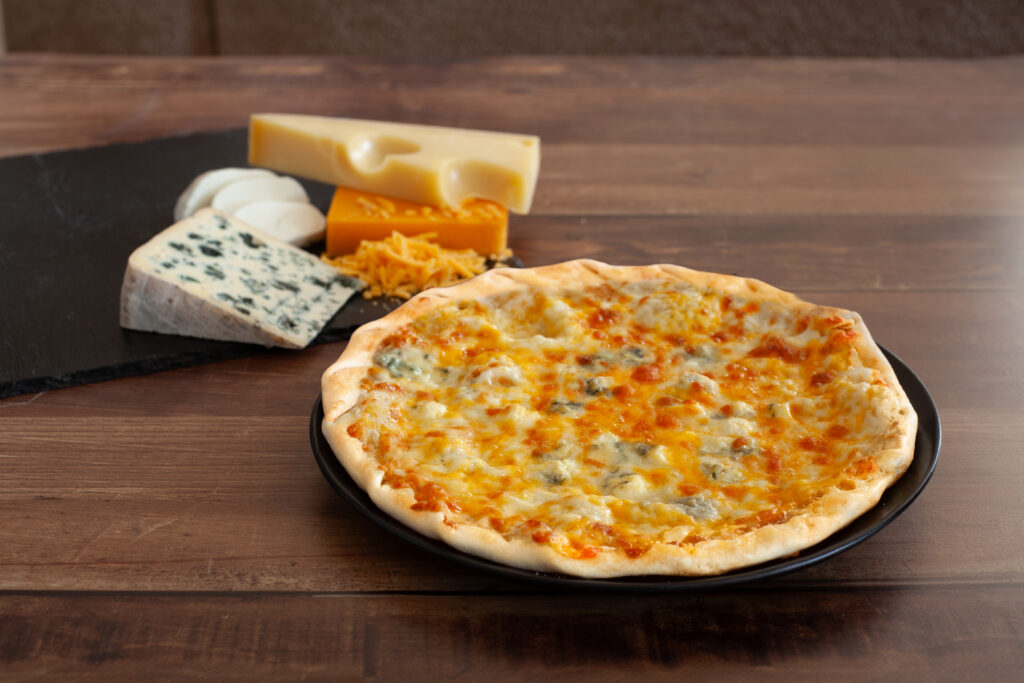 Tarte fine aux quatre fromages : cheddar rouge, emmental, mozzarella et bleu