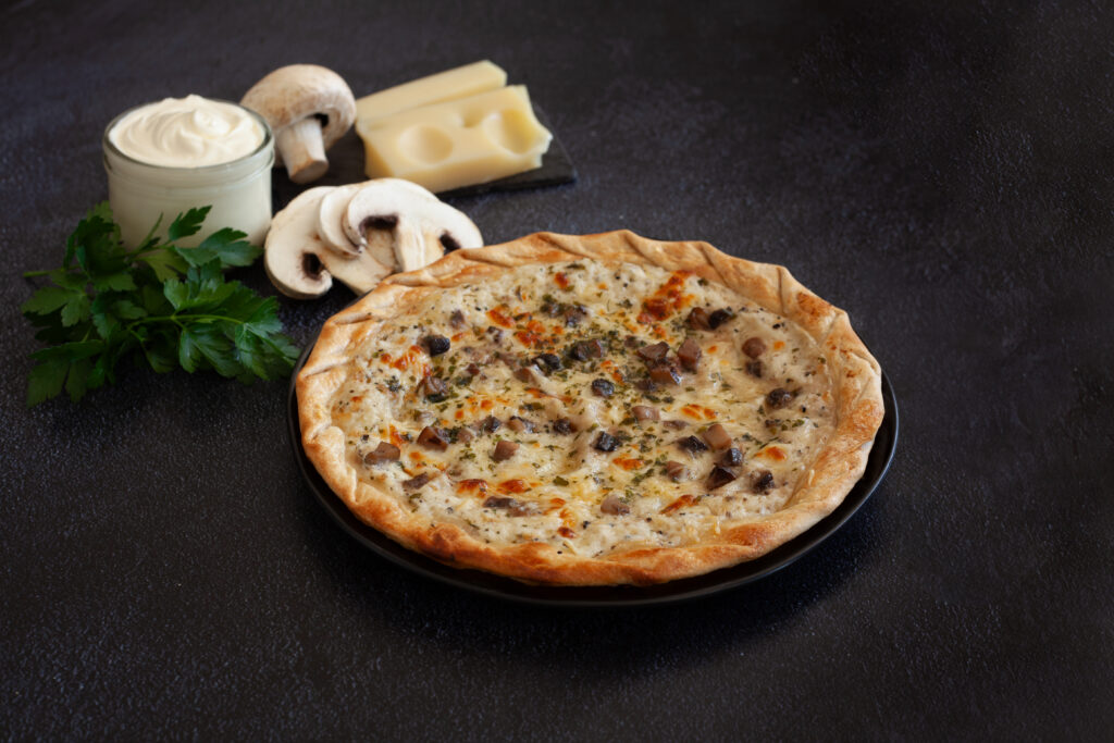 Tarte fine aux champignons de Paris et à l'emmental, relevée de persillade